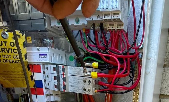 Licensed electrician performing electrical fault finding and safety testing with professional testing equipment in Perth